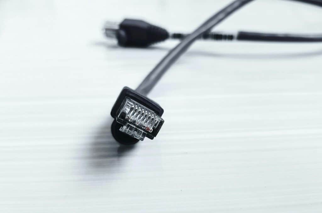 Detailed image of a black ethernet cable with RJ-45 connector on a white surface.