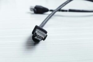 Detailed image of a black ethernet cable with RJ-45 connector on a white surface.